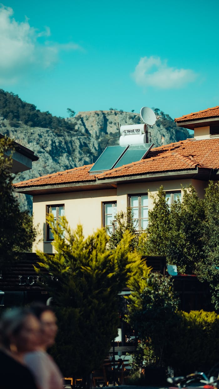 A picturesque urban house with solar panels and mountain view in the background.